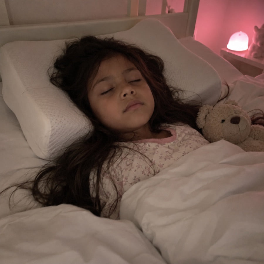 Niña dormida con pelo largo sobre la almohada